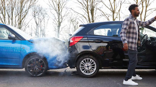 Carro azul batido de frente na traseira de um carro preto.